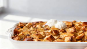 Classic Bread Pudding with Rich Butter Rum Sauce, golden brown and drizzled generously with creamy sauce, served in a bowl, comforting dessert