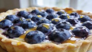 Beautifully arranged blueberry lemon tart with a golden crust and glossy fruit