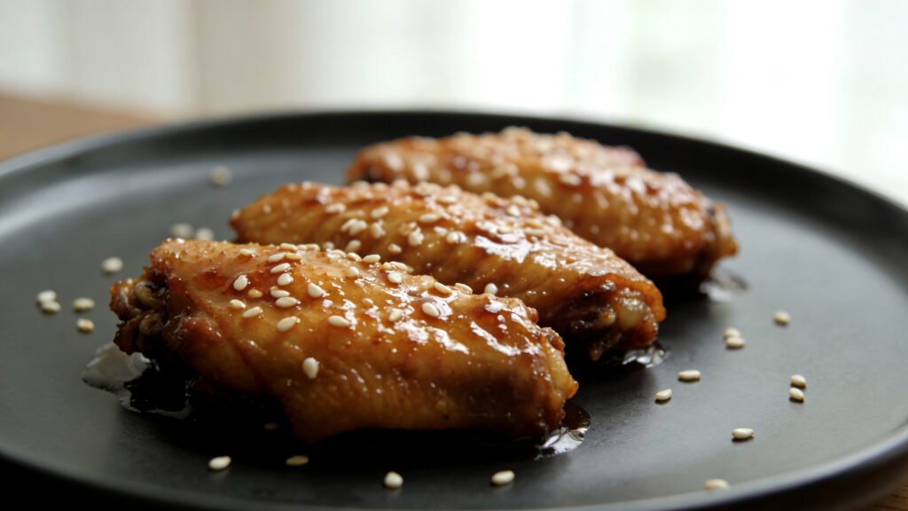 Glazed honey garlic chicken wings on a baking sheet, golden and sticky