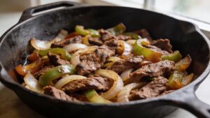 Juicy beef fajitas with caramelized peppers and onions on a platter