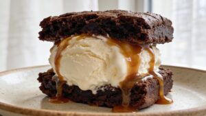 Fudgy brownie ice cream sandwich dripping with salted caramel