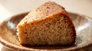 A slice of fall spiced tea cake on a plate with a cup of tea