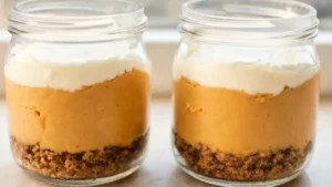 No-bake pumpkin cheesecake jars in glasses with whipped cream and cinnamon