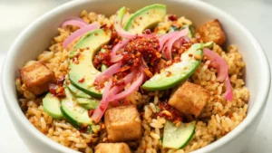 Crispy rice bowls with tofu and chili crisp on a wooden table