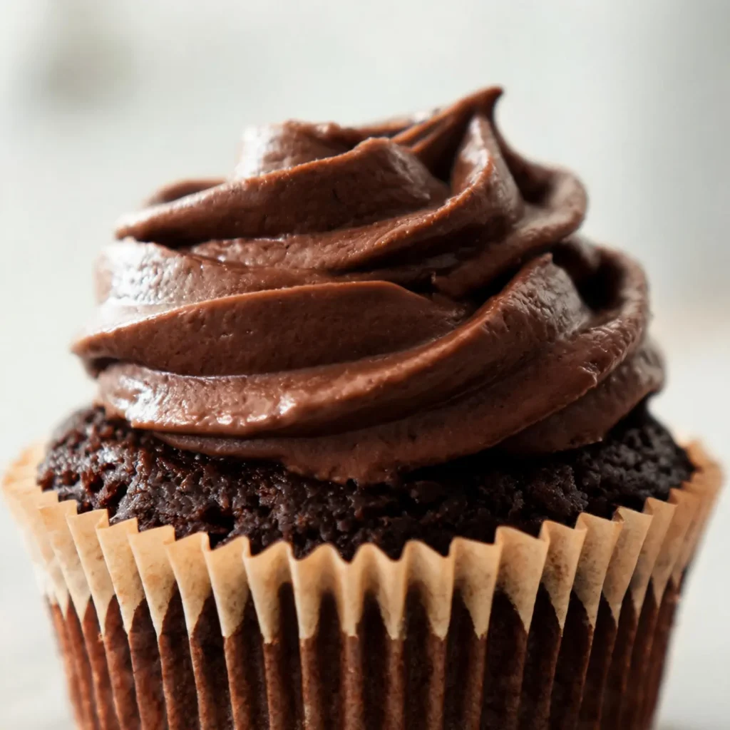 Chocolate cupcakes topped with glossy fudge frosting