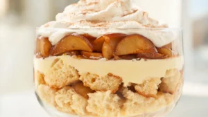 Apple cinnamon angel food trifle in a glass bowl with layers of cake, apples, and cinnamon cream
