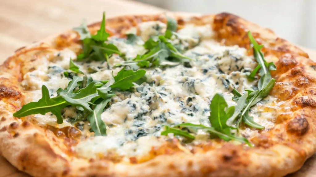 Gorgonzola flatbread with arugula on a serving board
