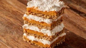 A stack of Pumpkin Spice Fluffernutter Bars on a wire rack, drizzled with marshmallow and pumpkin glaze