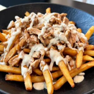 Shawarma loaded fries with garlic sauce served on a plate